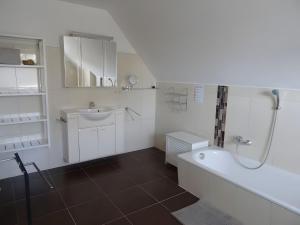 a bathroom with a tub and a sink and a shower at Ferienhaus Ferienhof Behnke in Süssau