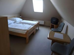 a small bedroom with two beds and a chair at Ferienhaus Ferienhof Behnke in Süssau