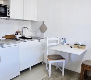 a white kitchen with a sink and a table at Bestlage - Gemütliche Wohnung in der Mainzer City in Mainz