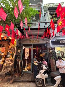 a store with red paper signs and a scooter parked outside at Skylux Hanoi Homestay in Hanoi