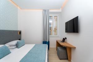 a bedroom with a bed and a desk with a television at Domus Gualtieri in Sorrento +31 photos
