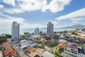 an aerial view of a city with buildings and the ocean at Estadia completa com piscina e academia a 400m da Praia da Armação - SKL in Penha