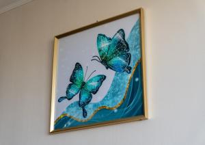 a picture of three butterflies on a wall at Departamento Calama in Calama