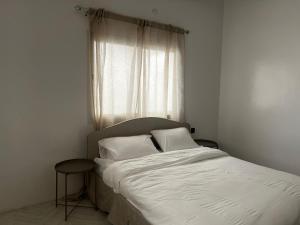 - un lit avec deux oreillers et une fenêtre dans une chambre dans l'établissement بيت الضباب, à Abha