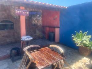 a patio with a wooden table and chairs and a restaurant at Casa ampla a 100 passos do mar, piscina, churrasqueira, salão de jogos in Saquarema