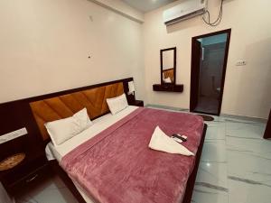 a bedroom with a large bed with a red blanket at Ram Sevak Hotel By Nandan in Ayodhya