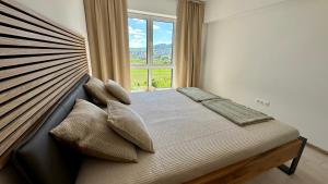 a bedroom with a bed with a large window at Meridian Suite in Sighişoara