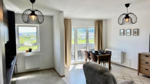 a living room with a table and chairs and windows at Meridian Suite in Sighişoara