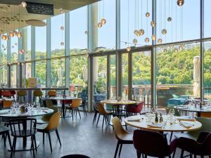 a restaurant with tables and chairs and windows at Novotel Lyon Centre-Confluence Bord de Saone in Lyon