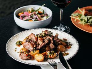 a plate with meat and a salad and a glass of wine at Novotel Lyon Centre-Confluence Bord de Saone in Lyon +52 photos