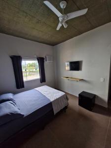 a bedroom with a bed and a ceiling fan at Pousada Praia do Guaiuba in Guarujá