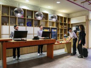 a group of people standing at a desk in a library at Aparthotel Adagio Berlin Kurfürstendamm in Berlin