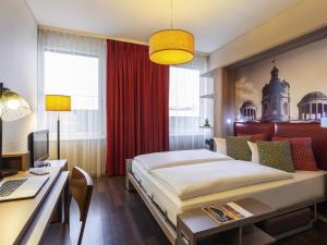 a bedroom with a bed and a desk with a computer at Aparthotel Adagio Berlin Kurfürstendamm in Berlin +82 photos