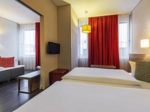 a bedroom with a white bed and a red curtain at Aparthotel Adagio Berlin Kurfürstendamm in Berlin +78 photos