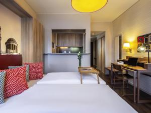 a bedroom with a bed and a desk with a laptop at Aparthotel Adagio Berlin Kurfürstendamm in Berlin