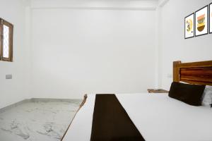 a bedroom with a bed with a black and white comforter at Hotel O Vrindavan Gardan & Hotel in Prayagraj +6 photos