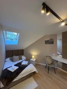 a attic bedroom with a bed and a desk at Babia Perła Zawoja in Zawoja