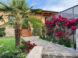 un giardino con palma e fiori rosa di Las Casitas de Cerezo a Cerezo de Abajo