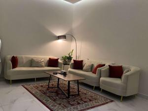 a living room with two couches and a coffee table at شقق الوسام الفندقية in Hafr Al Baten +2 photos