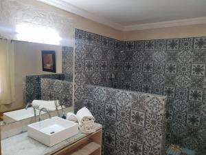 La salle de bains est pourvue d'un lavabo et d'un mur en carrelage. dans l'établissement Villa palmeraie Marrakech, à Najem