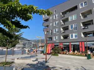 a building with people sitting outside of it next to the water at Sentrumsnær leilighet Bergen in Bergen