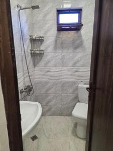 une salle de bain avec toilettes, lavabo et fenêtre dans l'établissement Family house in Kobuleti, à Kobuleti