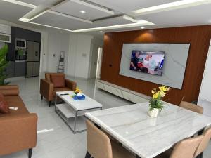 a living room with a table and a tv on a wall at Stunning 2 Bedroom Apartment Overlooking the Ocean in Dakar