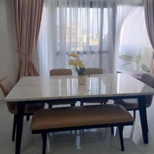 a dining room table with a vase of flowers on it at Stunning 2 Bedroom Apartment Overlooking the Ocean in Dakar
