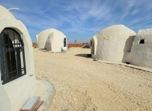 a group of domed buildings in the desert at Tootya camp in Al Mathlūthah