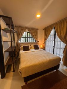 a bedroom with a large bed and a large window at La Aldea in Mocoa