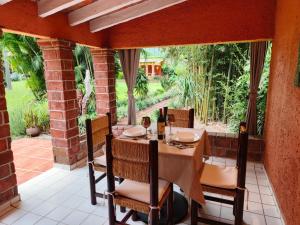 a dining room with a table and chairs on a patio at Portal Azahualco Bungalow close to the mountain in Tepoztlán