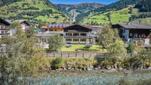 a large house with a fence in front of a mountain at Apartments Enzian in Rauris