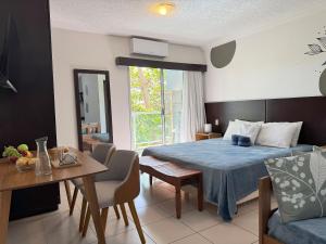 sypialnia z łóżkiem i stołem oraz jadalnia w obiekcie Loft beira-mar completo e confortável | MASD313 w mieście Macaé