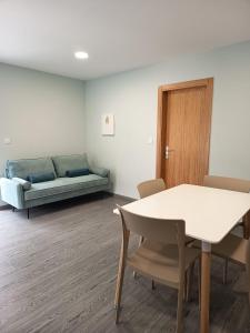 un salon avec un canapé, une table et des chaises dans l'établissement Pousada Teixeira 11A, à São Vicente