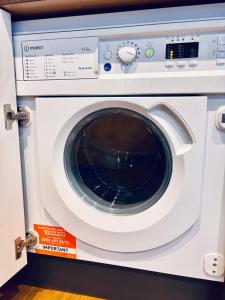 a white washing machine is on display in a store at Cozy Double Room with Private Shower in Hampton Lakes in Peterborough