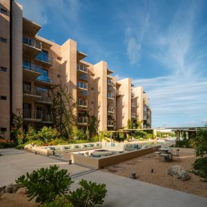 an apartment building with a swimming pool in front of it at Bohari Las Arenas in Cabo San Lucas