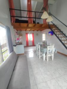 a living room with a table and a staircase at Alquiler temporario Romina in Tandil