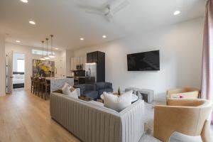 a living room with a couch and chairs and a kitchen at Broadway Breakaway I Rooftop HotTub in Nashville