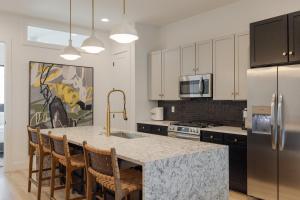 a kitchen with a large kitchen island with chairs around it at Broadway Breakaway I Rooftop HotTub in Nashville