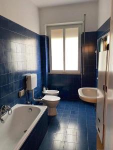 a blue and white bathroom with a tub and toilet at CASA di Pi in Bologna +2 photos