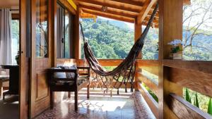 a hammock in a room with a large window at Recanto bela Vista caminho do ouro in Paraty