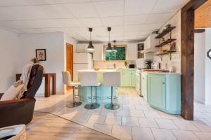 a kitchen with mint green cabinets and a table at L'Évasion - 4CH - Piscine - Spa et Salle de jeux in Saint Zenon +38 photos