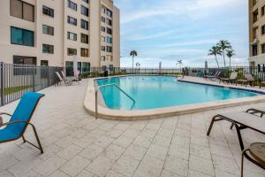 a swimming pool with chairs and tables in a building at 4 Mi to Lovers Key SP Modern Condo with Ocean Views in Fort Myers Beach