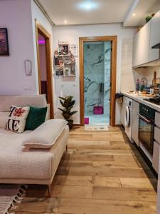 Una sala de estar con un sofá y una cocina. en Hammamet appart with pool, en Nabeul