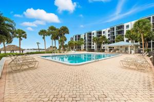 ein Swimmingpool mit Stühlen und einem Gebäude in der Unterkunft Island Whispers Hideaway in Marco Island