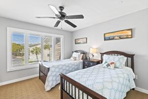 ein Schlafzimmer mit zwei Betten und einem Deckenventilator in der Unterkunft Seagrove Villa 11C - Oceanfront View! Center of Resort! in Isle of Palms