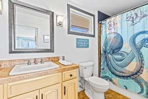 ein Badezimmer mit Waschbecken, Toilette und Duschvorhang in der Unterkunft Seagrove Villa 11C - Oceanfront View! Center of Resort! in Isle of Palms + 31 Fotos