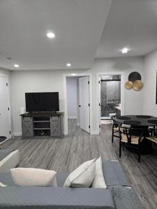 a living room with a couch and a tv at The Willow Nest lower suite-2 Rooms in Calgary