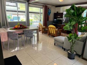a living room with a table and chairs at Vainoa house in Tikehau