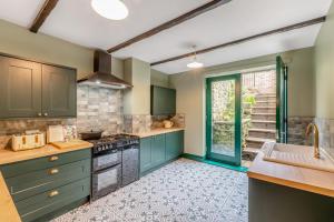 een keuken met groene kasten en een spoelbak bij Bondgate House in Alnwick +24 foto's